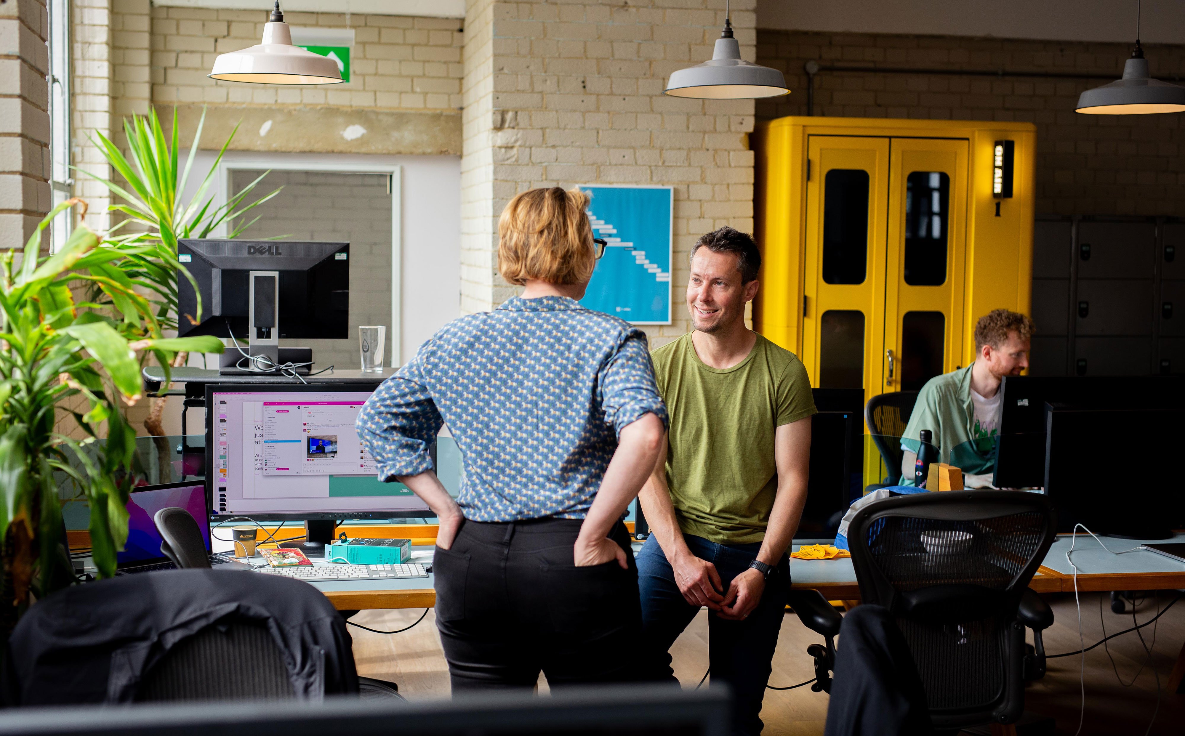 Some ustwobies chatting around a laptop